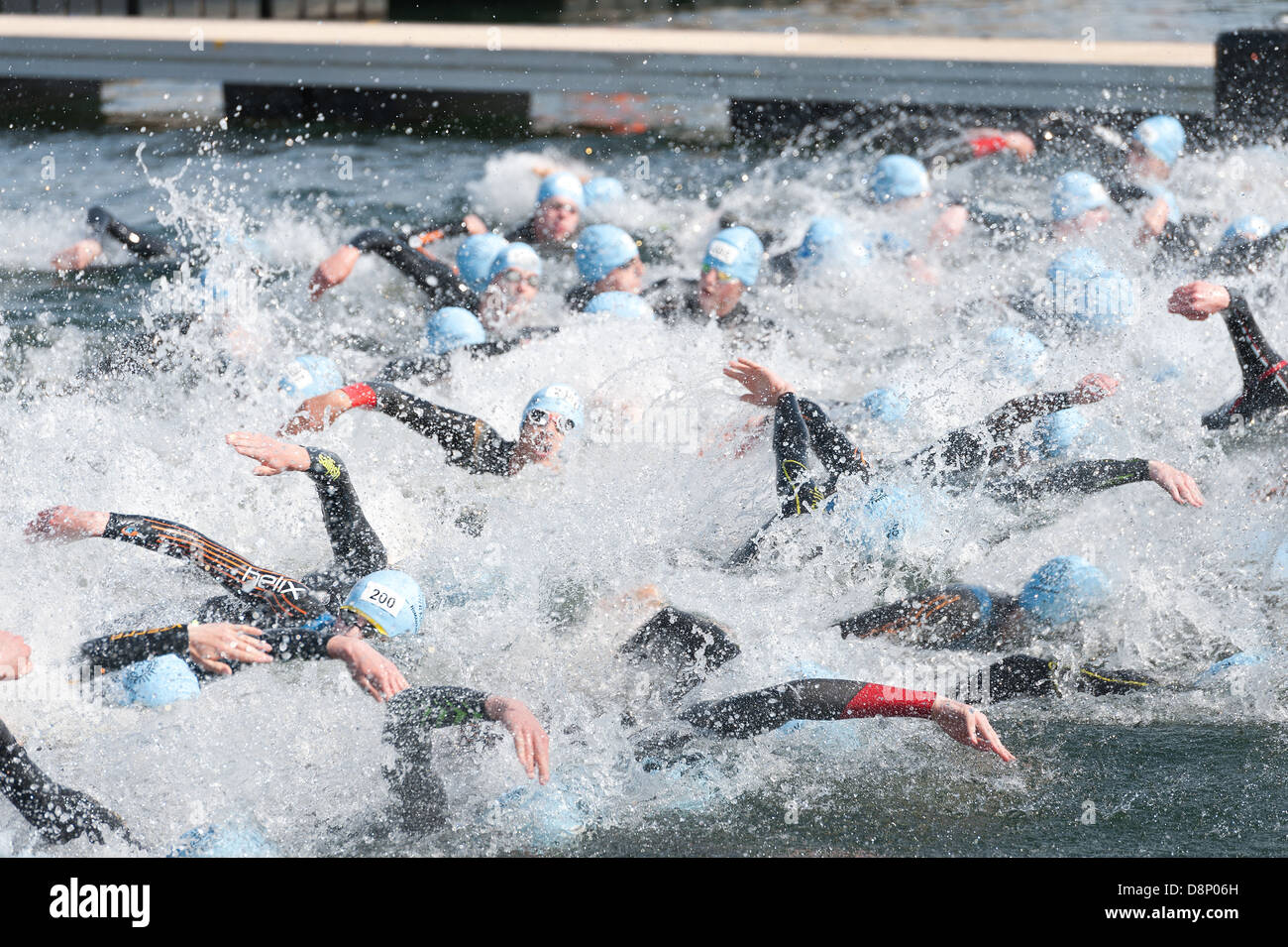Freiwasser schwimmen männliche Konkurrenten sprinten zu Beginn einen Triathlon im Süßwasser tragen Wetsuits Crawl Tiefe Start freestyle Stockfoto