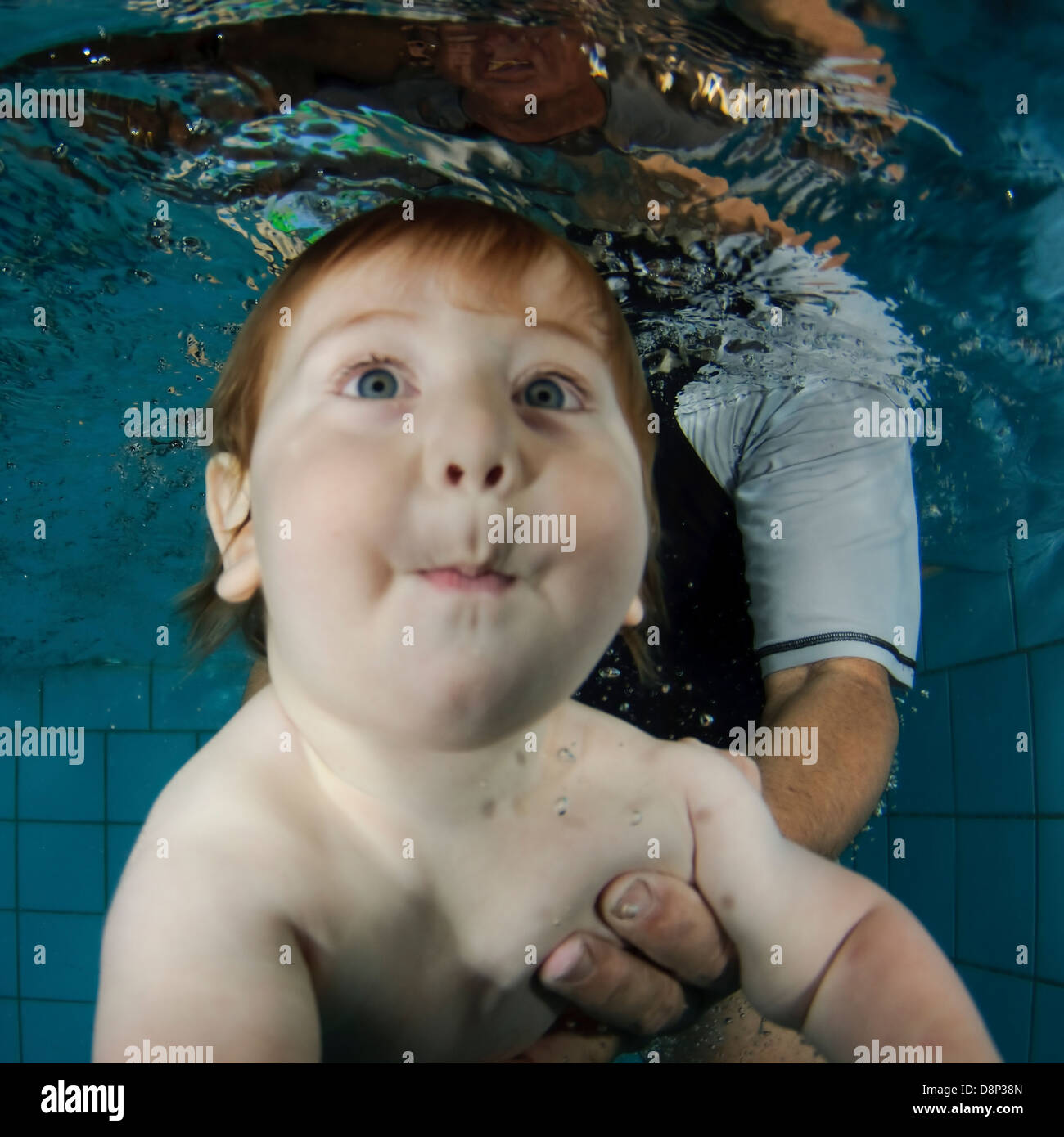 1 Jahr altes Baby wird unter Wasser von seiner Mutter unterstützt Stockfoto