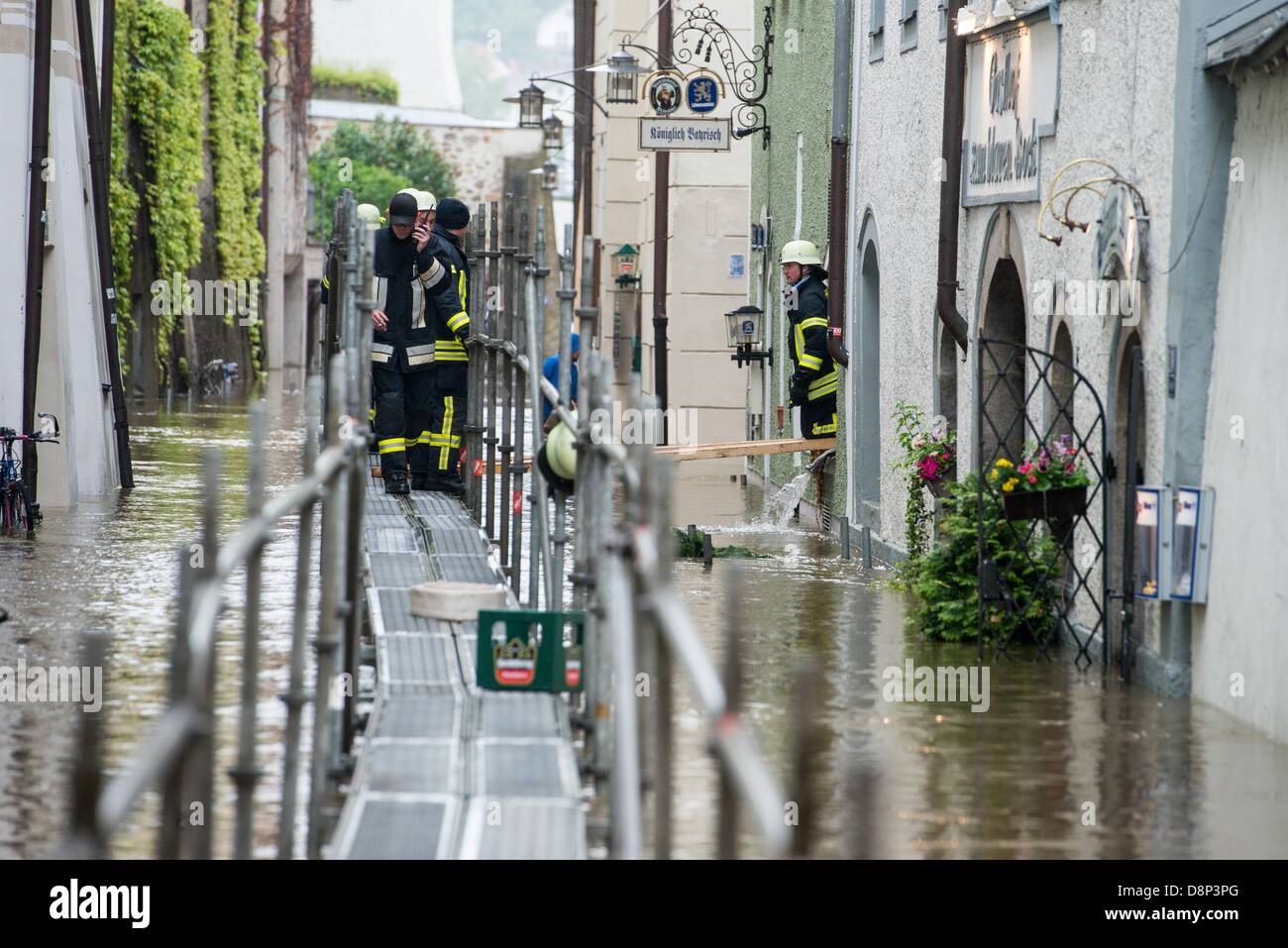Passau, Deutschland. 2. Juni 2013. Feuerwehrleute gehen über eine Brücke in einer Straße überflutet von Donau in Passau, Deutschland, 2. Juni 2013 installiert. Extreme Regenfälle verursachen viele Überschwemmungen in der Gegend. FOTO: ARMIN WEIGEL Stockfoto
