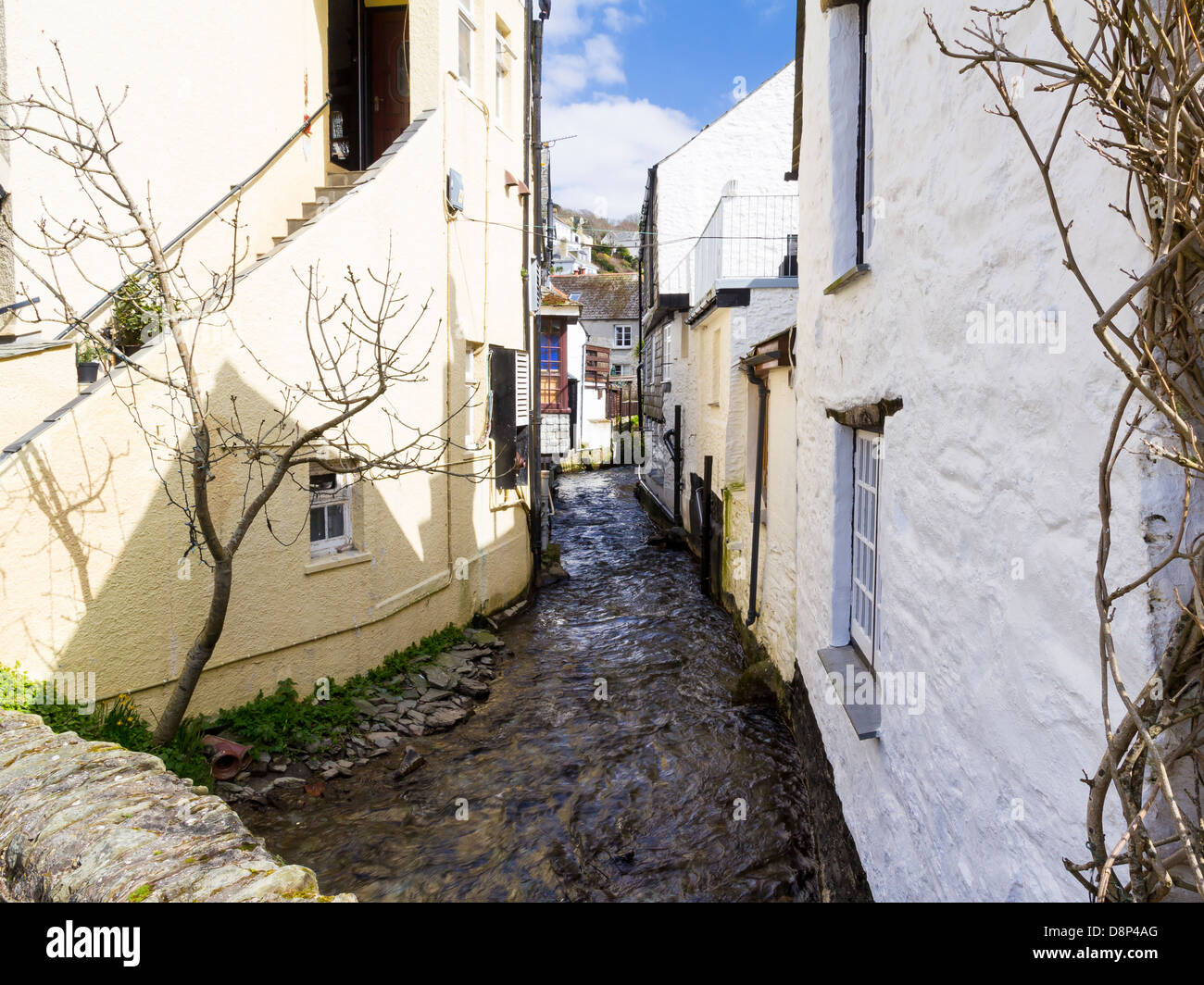 Zwischen den malerischen Hütten des Dampfes, der durch das Dorf Polperro Cornwall England UK läuft anzeigen Stockfoto