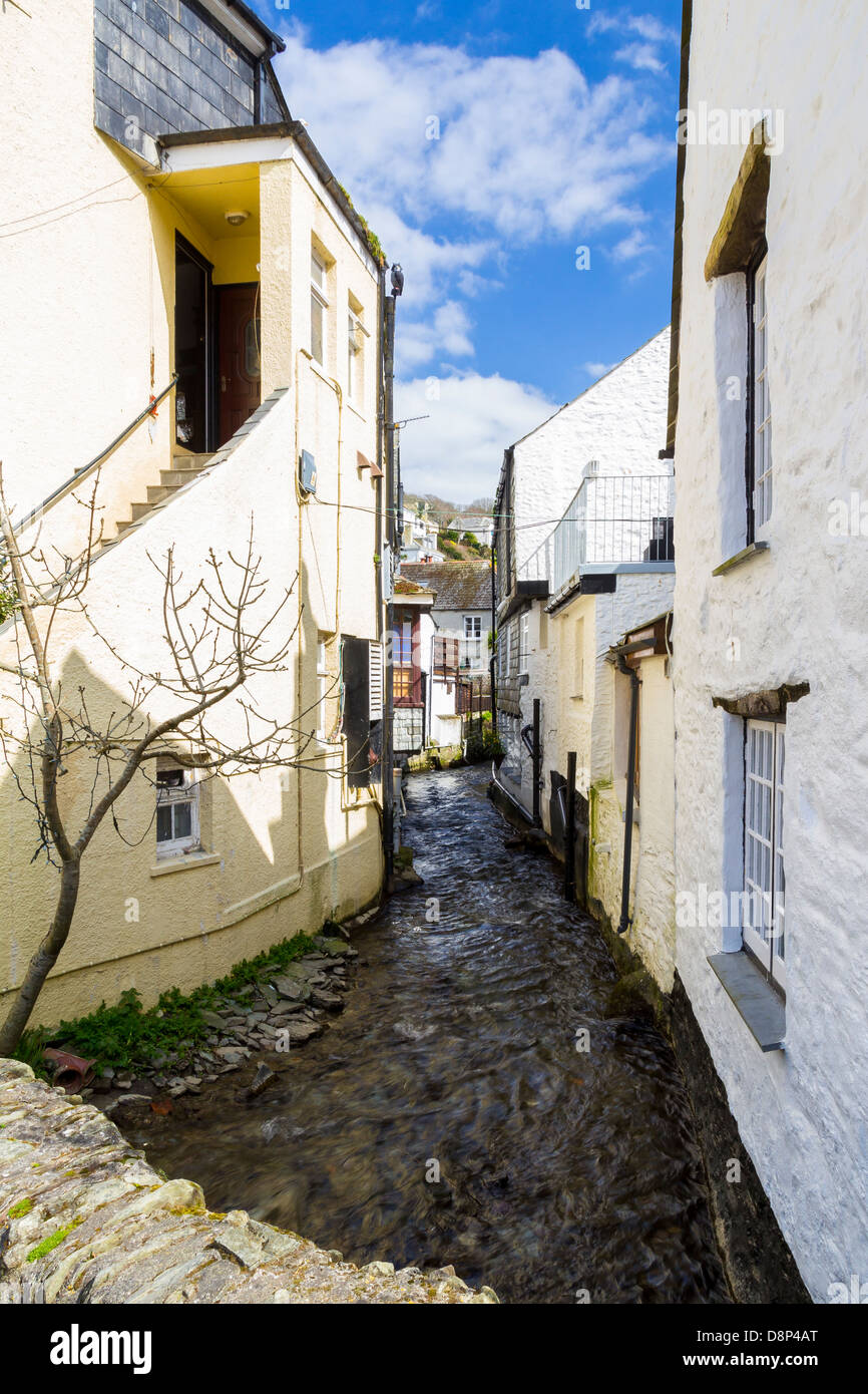 Zwischen den malerischen Hütten des Dampfes, der durch das Dorf Polperro Cornwall England UK läuft anzeigen Stockfoto