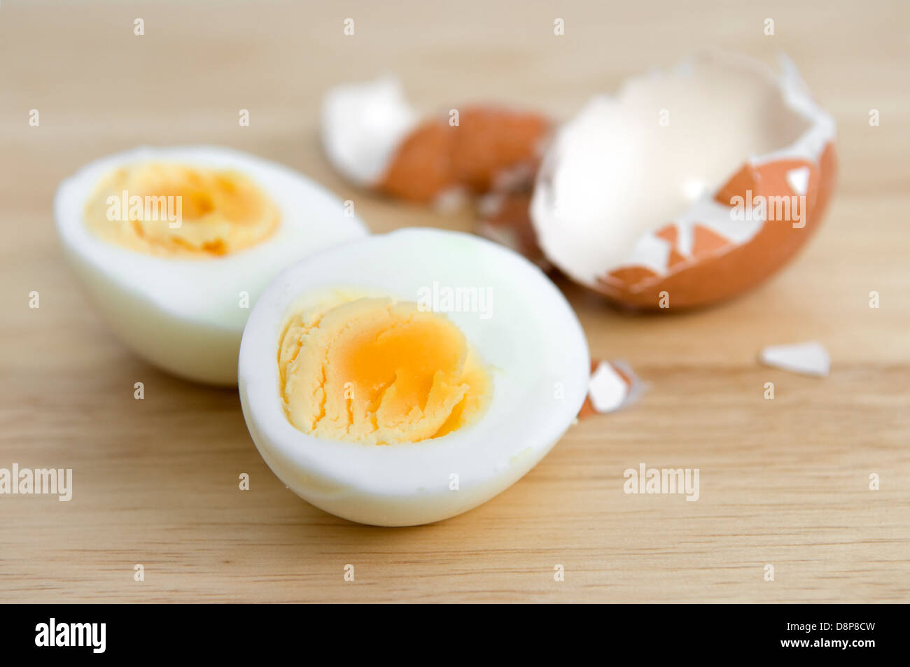 Hartes gekochtes Ei halbieren mit Eierschale auf Schneidbrett aus Holz Stockfoto