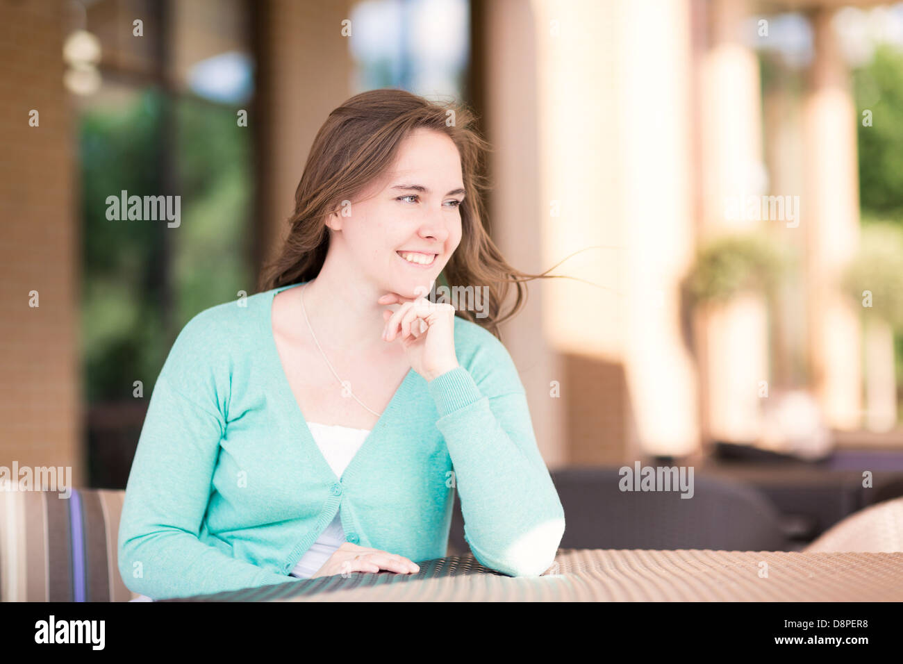 Wunderschöne lächelnde Frau sitzt in einem Café outdor Stockfoto
