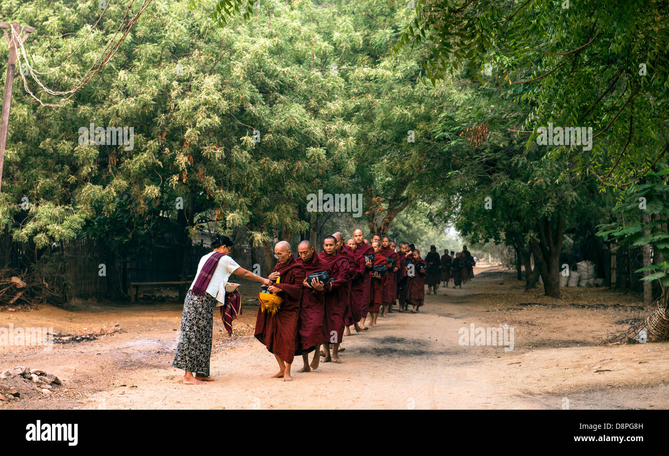 Buddhistische Mönche sammeln von Almosen Schüsseln mit Essen am Morgen von Dorfbewohnern in der Nähe von Bagan Burma Myanmar Stockfoto