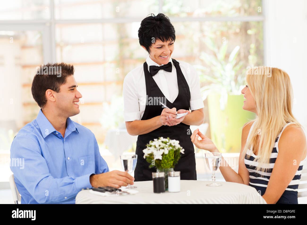 freundliche mittleren gealterten Kellnerin unter Bestellung von Kunden