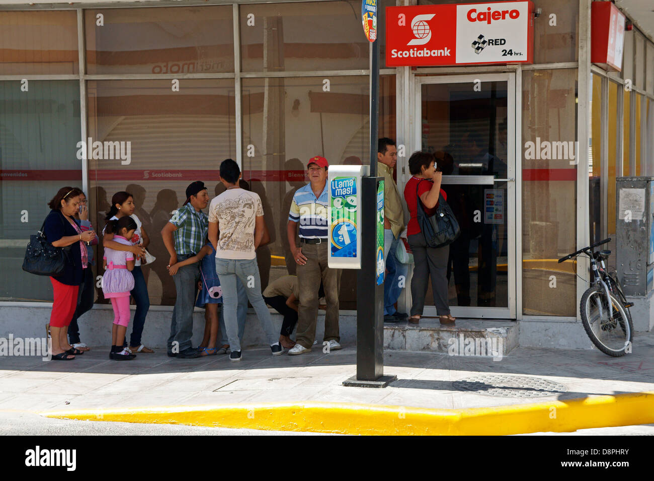 Mexikanische Menschen Schlange, um die atm vor einer Bank in Merida, Yucatan, Mexiko verwenden Stockfoto
