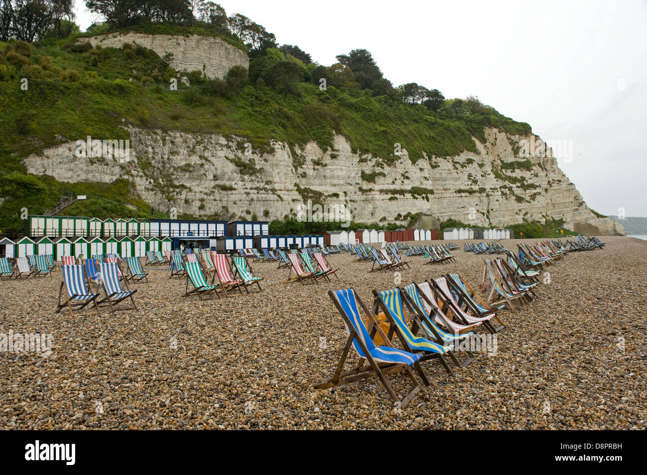 Nassen Sommertag am Strand von Bier in Devon mit ungenutzten Liegestühle Stockfoto