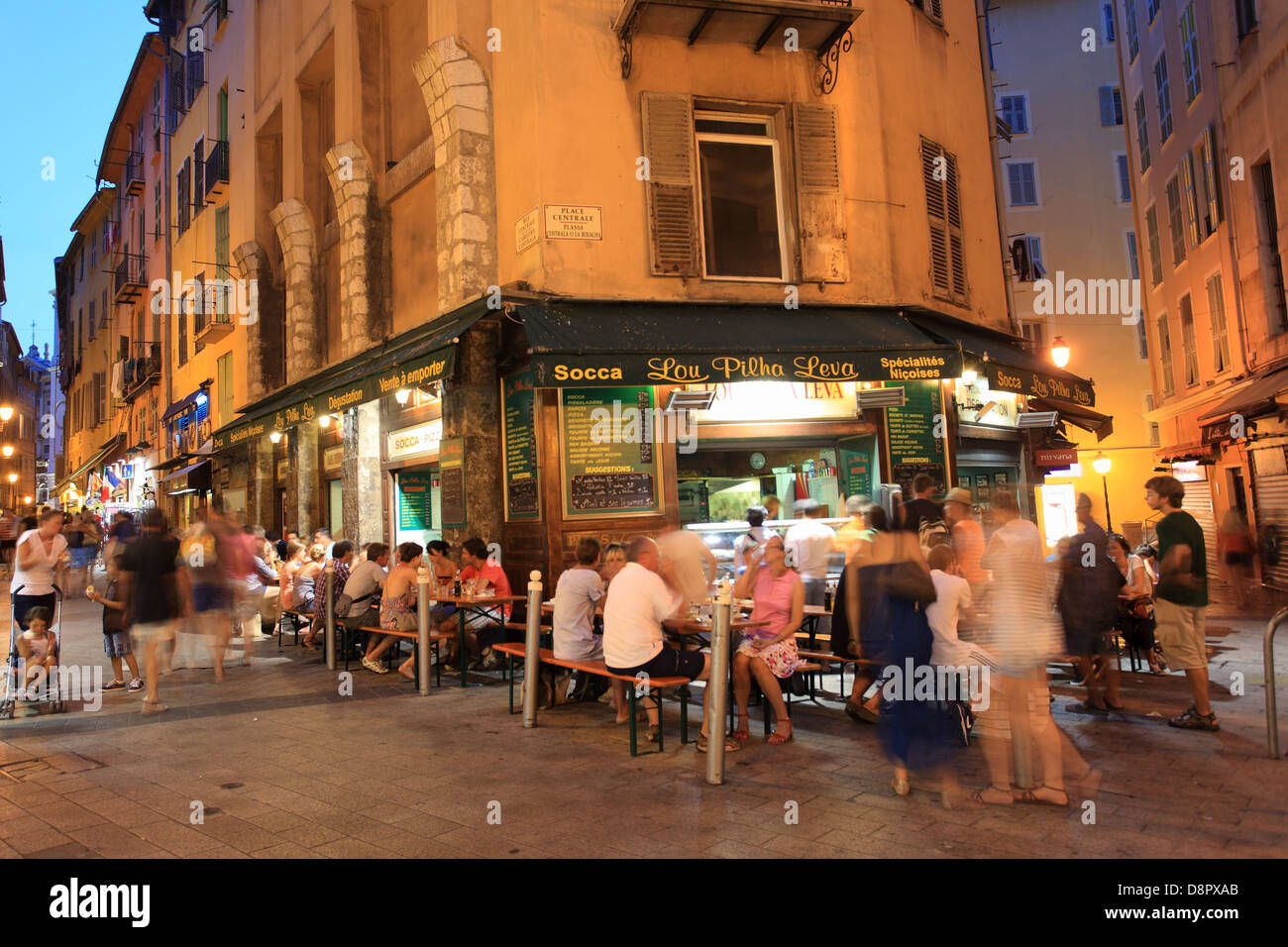 Menschen mit Abendessen außerhalb in einem Restaurant servieren Spezialitäten wie Socca in der Altstadt von Nizza Altstadt in der Nacht. Stockfoto