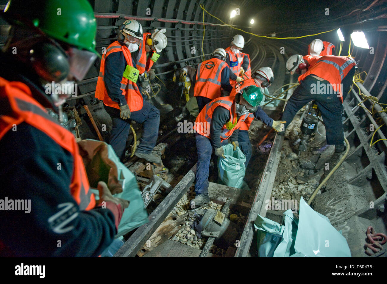 Arbeitnehmer über Graben, Absacken und schleppen die alte konkrete Bettwäsche Weg von der Seite gesetzt. Ersetzen alte Schienen. Stockfoto