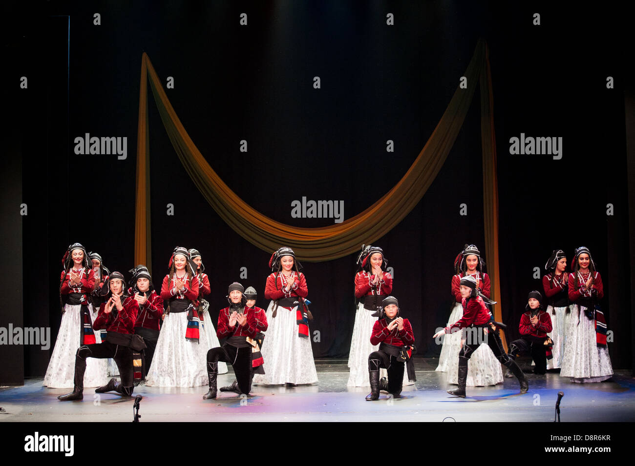 Georgische Kinder gekleidet mit traditionellen Kostümen tanzen eine Folklore-Tanz-Show auf der Bühne. Stockfoto