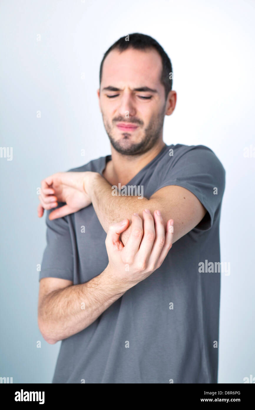 MANN MIT SCHMERZHAFTEN ELLENBOGEN Stockfoto