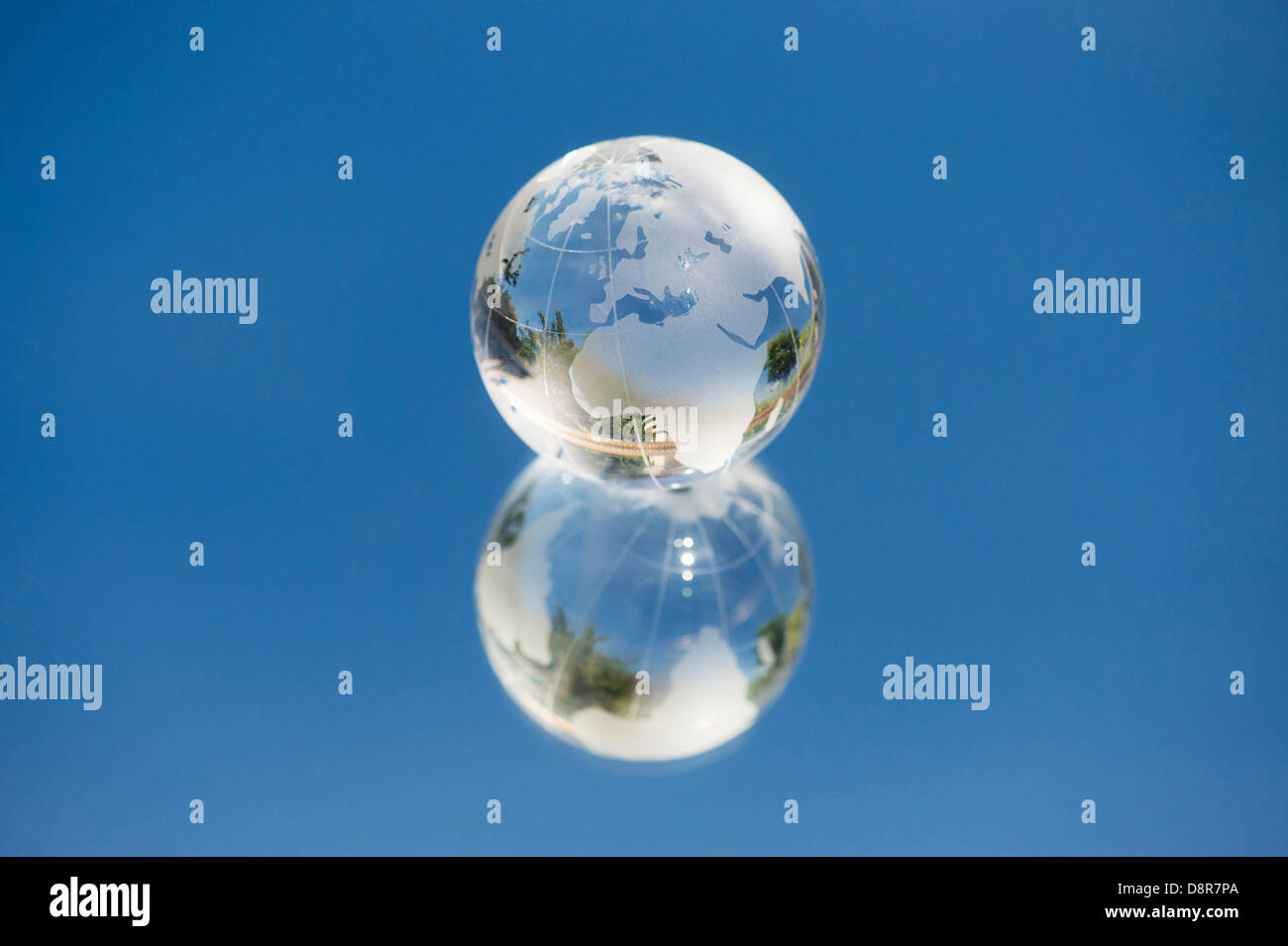 Kristall Glas Globus / Erde / Welt auf ein Spiegel-blauen Himmel Stockfoto