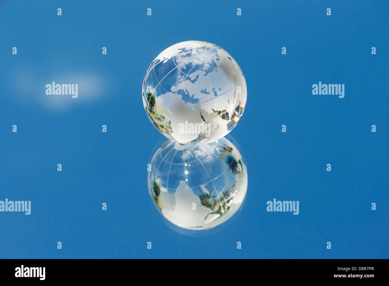 Kristall Glas Globus / Erde / Welt auf ein Spiegel-blauen Himmel Stockfoto