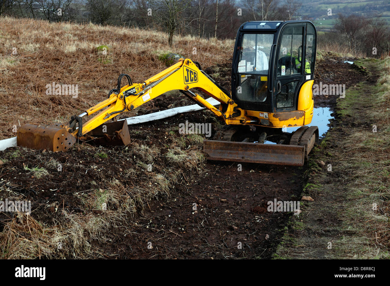 JCB Mini Digger Bau eines Hügelwegs, Schottland, Großbritannien Stockfoto