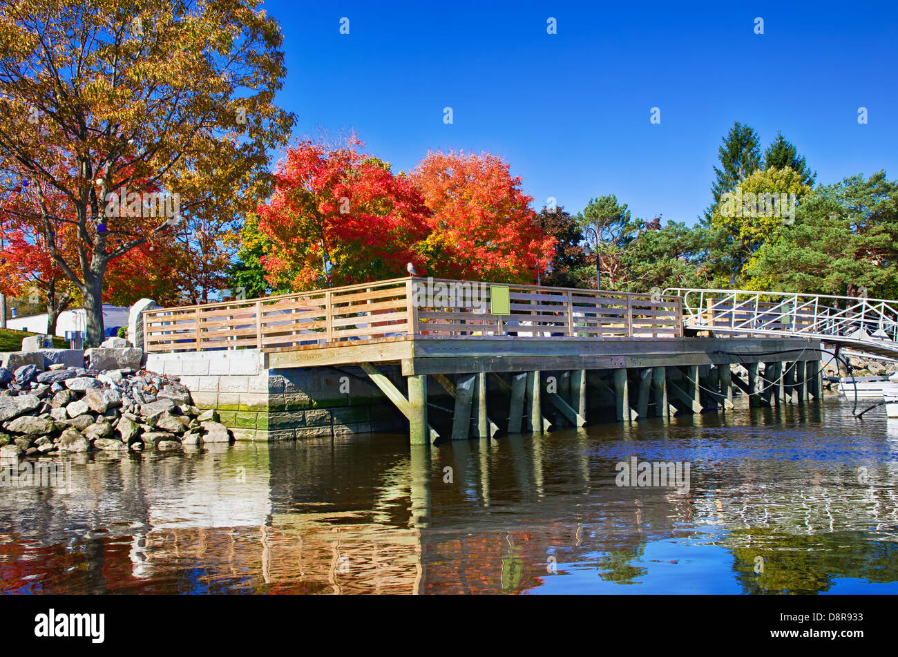 Pier auf einem Fluss umgeben von Herbstfarben Stockfoto