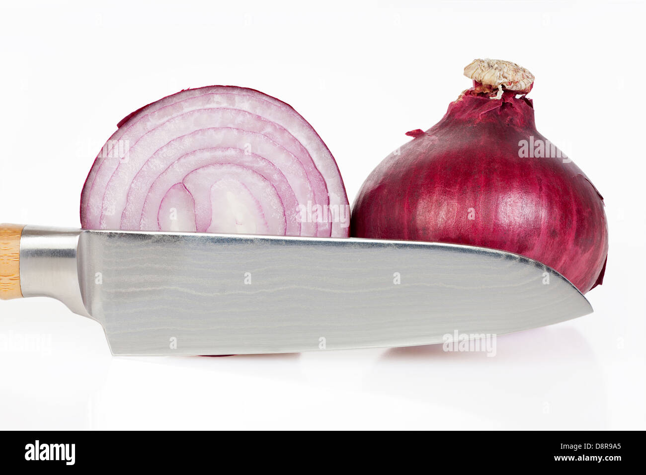 Ganze und geschnittene rote Zwiebeln mit Messer vor weißem Hintergrund Stockfoto