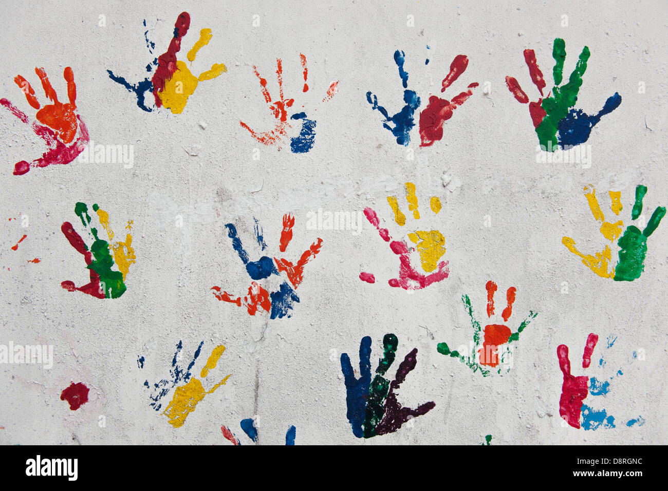 Mehrere farbige Hand druckt auf weiße Wand Hintergrund. Stockfoto