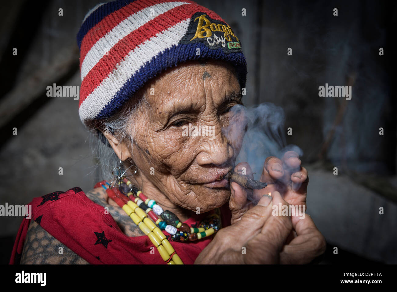 Porträt einer alten philippinische Frau Beleuchtung eine Zigarre, Tinglayan, Kalinga, North Luzon, Philippinen Stockfoto