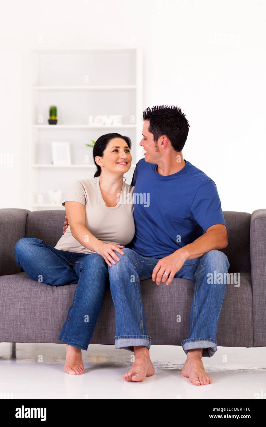 junges Paar sitzt zu Hause auf sofa Stockfoto