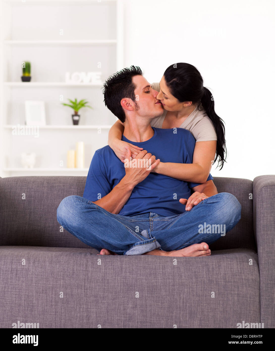 junge Paar küssen zu Hause auf sofa Stockfoto