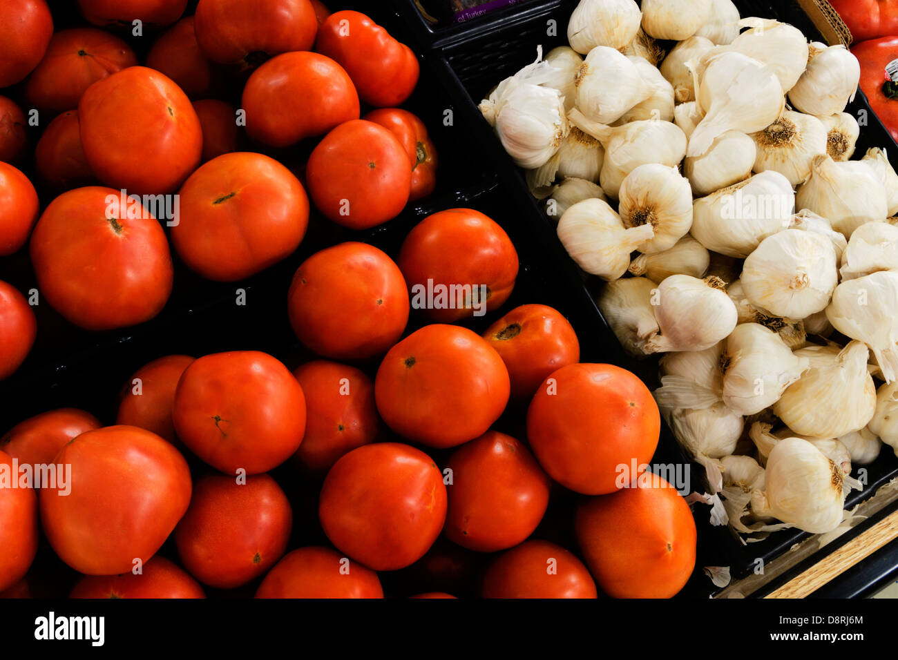 Tomaten und Knoblauch auf dem Display in einer Familie im Besitz Lebensmittelgeschäft. Stockfoto