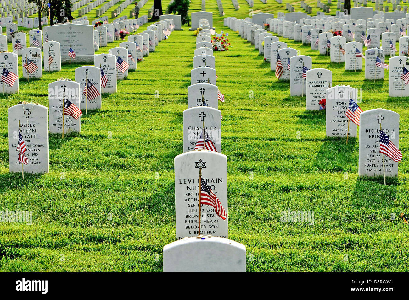 Amerikanische Flaggen vor Grabsteine auf dem Arlington National Cemetery zu Ehren des Memorial Day 23. Mai 2013 in Arlington, VA. Jährlich, da die alte Garde im Jahr 1948 als offizielle zeremonielle Armee-Einheit bezeichnet wurde, wurde diese Tradition, bekannt als "Flags In," durchgeführt. Stockfoto