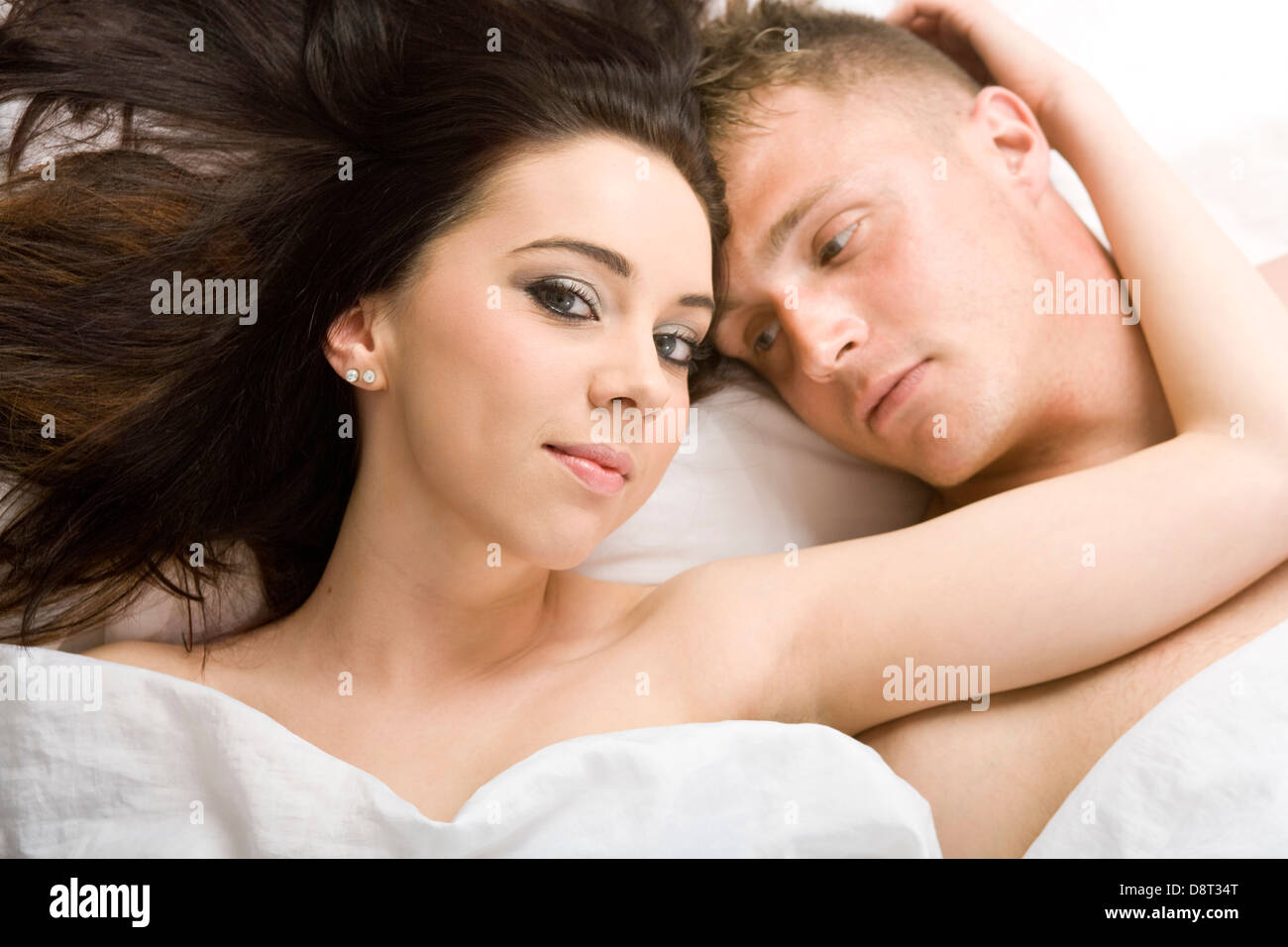 Ein junges Paar, liegend im Bett von oben betrachtet. Stockfoto