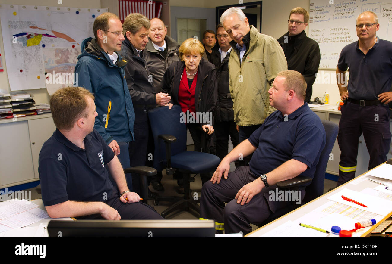 Pirna, Deutschland. 4. Juni 2013. German chancellor Angela Merkel (C), Premier von Sachsen Stanislaw Tillich (2-R), Bürgermeister von Pirna Klaus-Peter Hanke (4-L), deutsche Bundesinnenminister Hans-Peter Friedrich und andere Politiker betrachten einen Monitor mit den aktuellen Wasserstand in der Feuerwehr unmittelbar Zimmer in Pirna, Deutschland, 4. Juni 2013. Foto: ARNO BURGI/Dpa/Alamy Live-Nachrichten Stockfoto