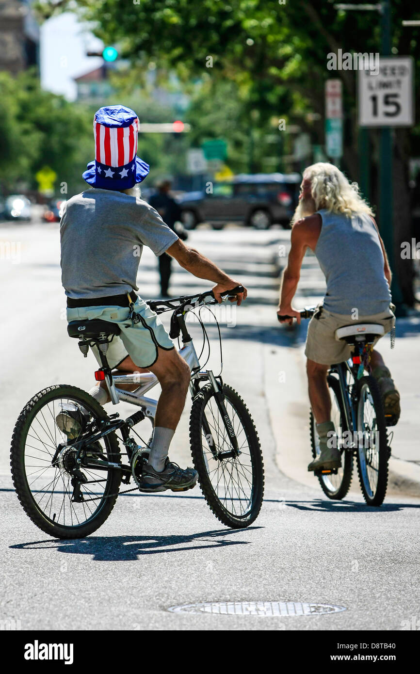 Mann einen Hut beginnt und Streifen während Radfahren in der Innenstadt von Sarasota Florida Stockfoto