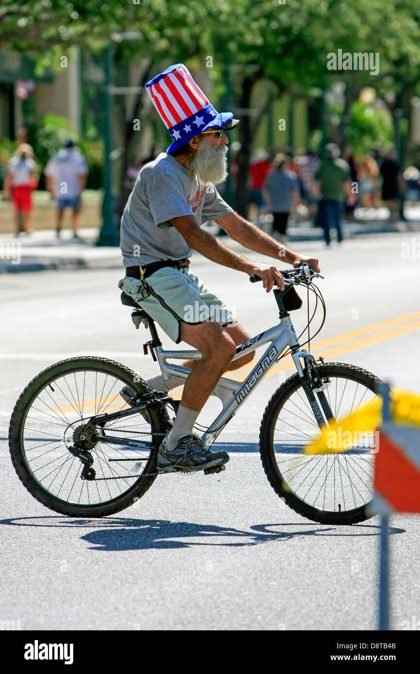 Mann einen Hut beginnt und Streifen während Radfahren in der Innenstadt von Sarasota Florida Stockfoto