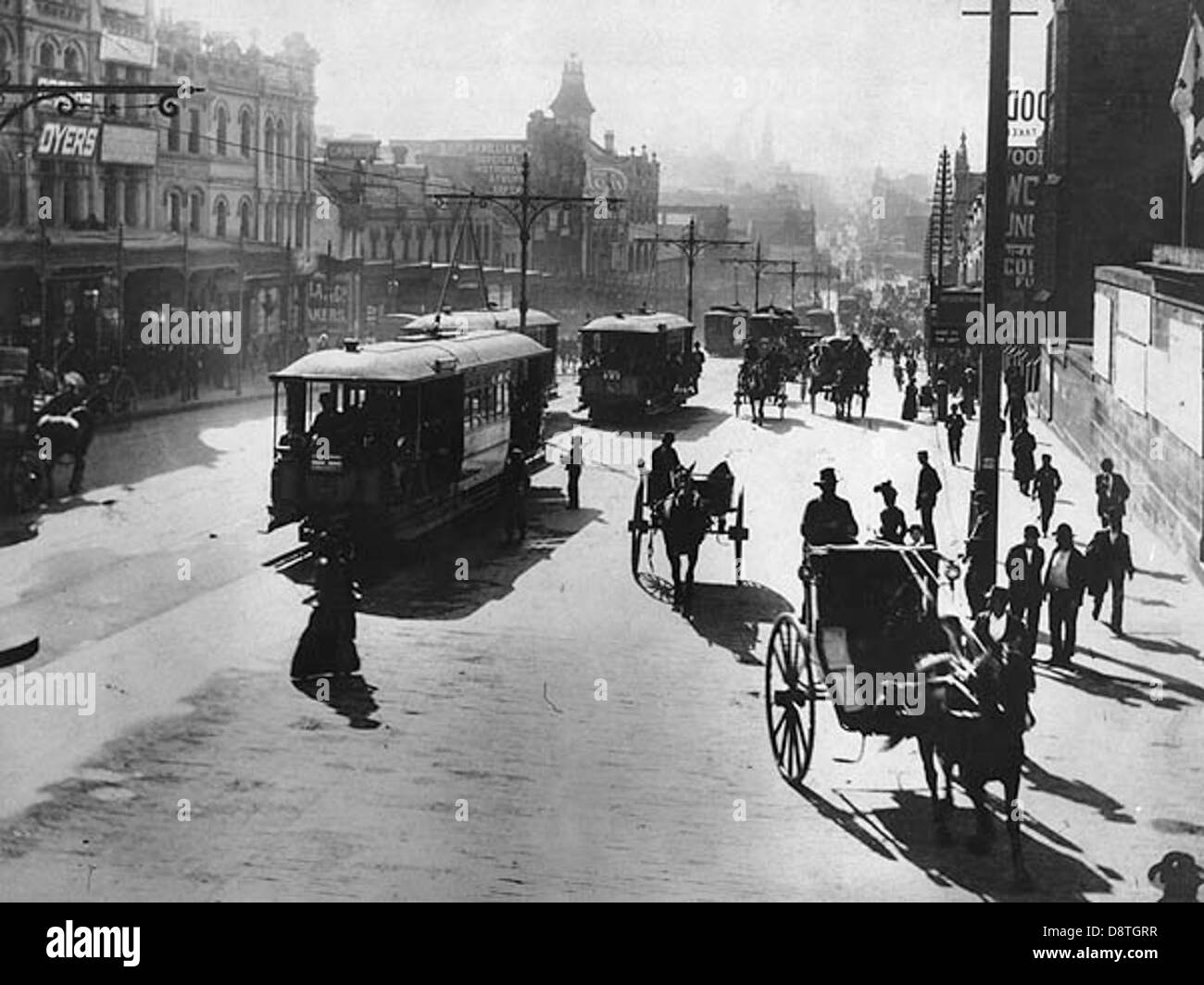Dieses Schwarzweiß-Foto zeigt die George Street in Sydney, Australien, um 1900 und erfasst die architektonische Landschaft der Stadt, darunter Pferdewagen, Fußgänger und Geschäfte. Sie bietet einen Einblick in Sydneys urbanes Leben im frühen 20. Jahrhundert. Stockfoto