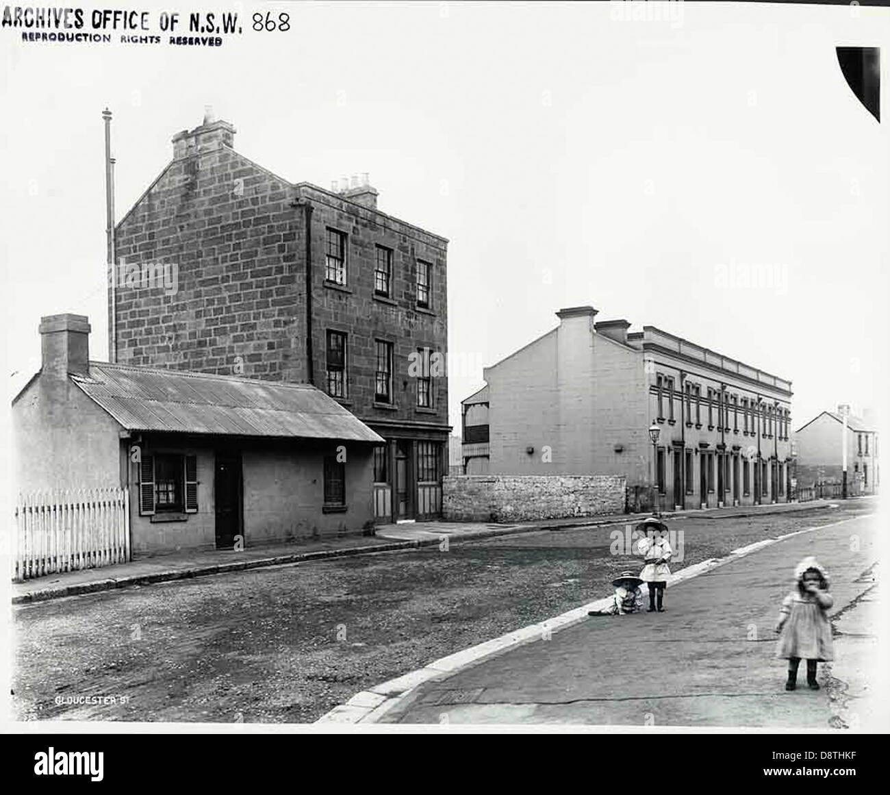 Das Ship & Mermaid Hotel befindet sich in der Gloucester Street in The Rocks, Sydney und ist in den Archiven von State Records NSW enthalten. Dieses historische Schwarzweiß-Bild fängt das Hotel und seine Umgebung ein und spiegelt das Erbe und den Charakter des Sydney Anfang des 20. Jahrhunderts wider, in dem Kinder und lokale Persönlichkeiten zu sehen sind. Stockfoto