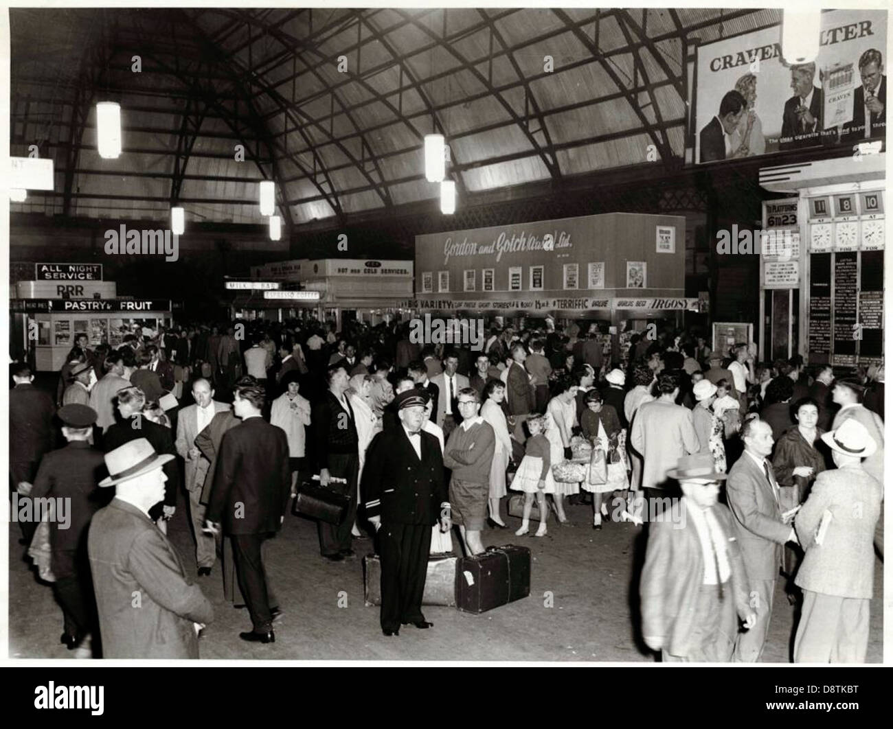 Ein historisches Schwarzweiß-Foto, das Menschen zeigt, die am Hauptbahnhof in New South Wales warten. Das Bild fängt die Mode und soziale Atmosphäre der damaligen Zeit ein, mit Frauen in Uniform und Menschenmassen im Bahnhof. Stockfoto