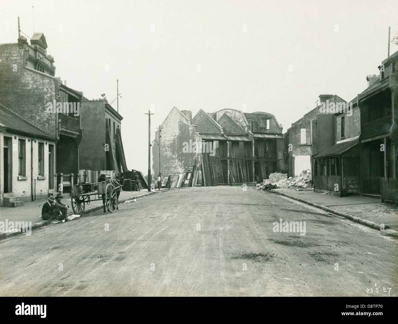 Dieses Schwarzweiß-Foto von Princes Street in Sydney aus dem Jahr 1927 zeigt eine Szene mit Menschen und Pferdewagen, die an Häusern vorbeifahren. Es bietet einen historischen Einblick in das tägliche Leben und die urbane Landschaft von New South Wales im frühen 20. Jahrhundert. Stockfoto