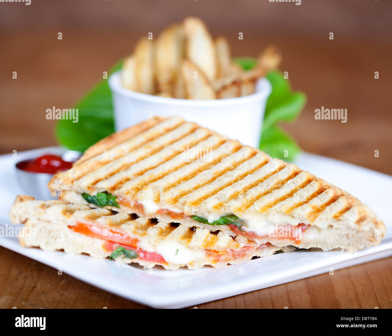 Gegrillte Caprese Sandwich mit Pommes Frites und Ketchup auf einem Teller Stockfoto