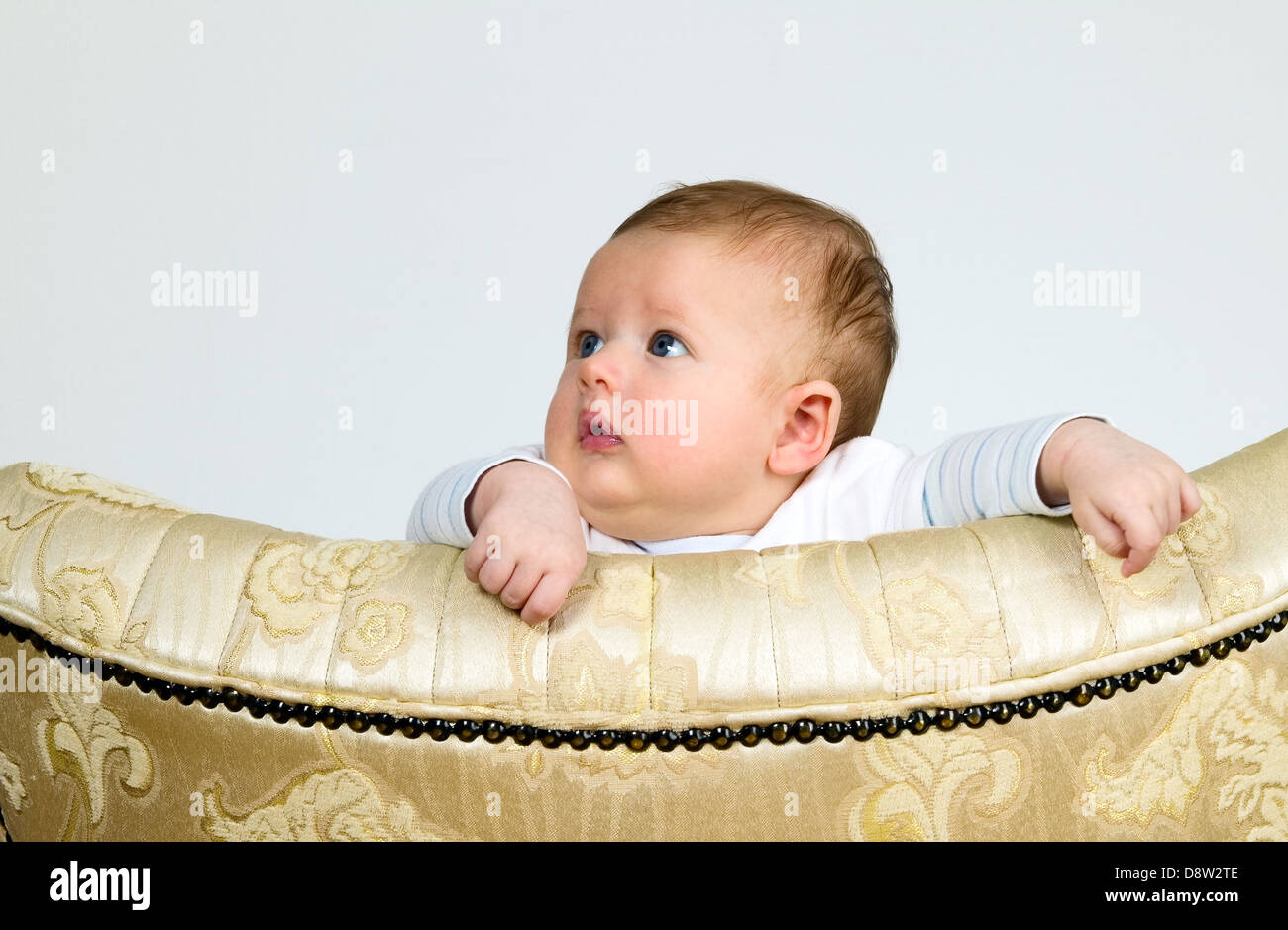 Baby Boy ist durch ein Top-Vintage Sessel beobachten. Stockfoto