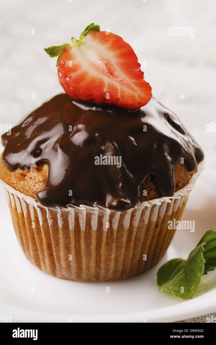 Schoko-Muffin mit Erdbeere an der Spitze Stockfoto