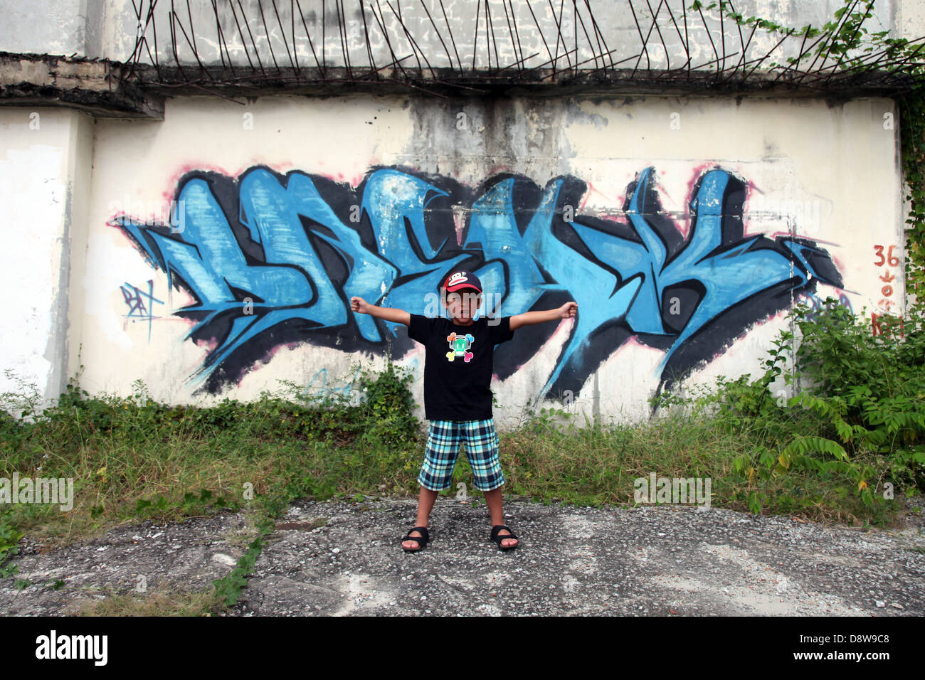 Es ist ein Foto von einer blauen Graffiti gegen eine zerstörte Wand in einer Einöde einer Stadt in Malaysia. Wir können sehen, dass es ein Industriegebiet ist Stockfoto