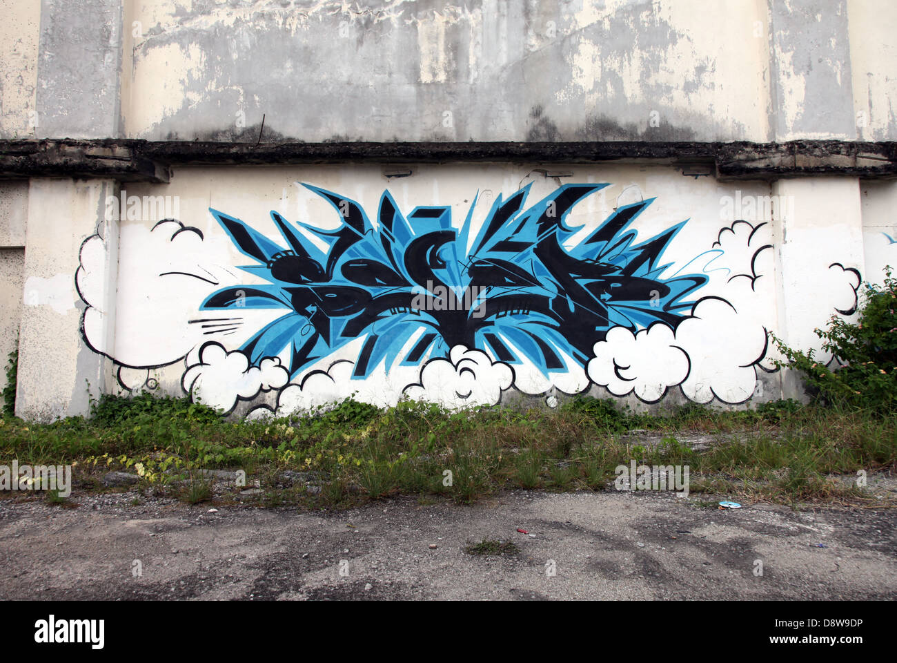 Es ist ein Foto von einer blauen Graffiti gegen eine zerstörte Wand in einer Einöde einer Stadt in Malaysia. Wir können sehen, dass es ein Industriegebiet ist Stockfoto