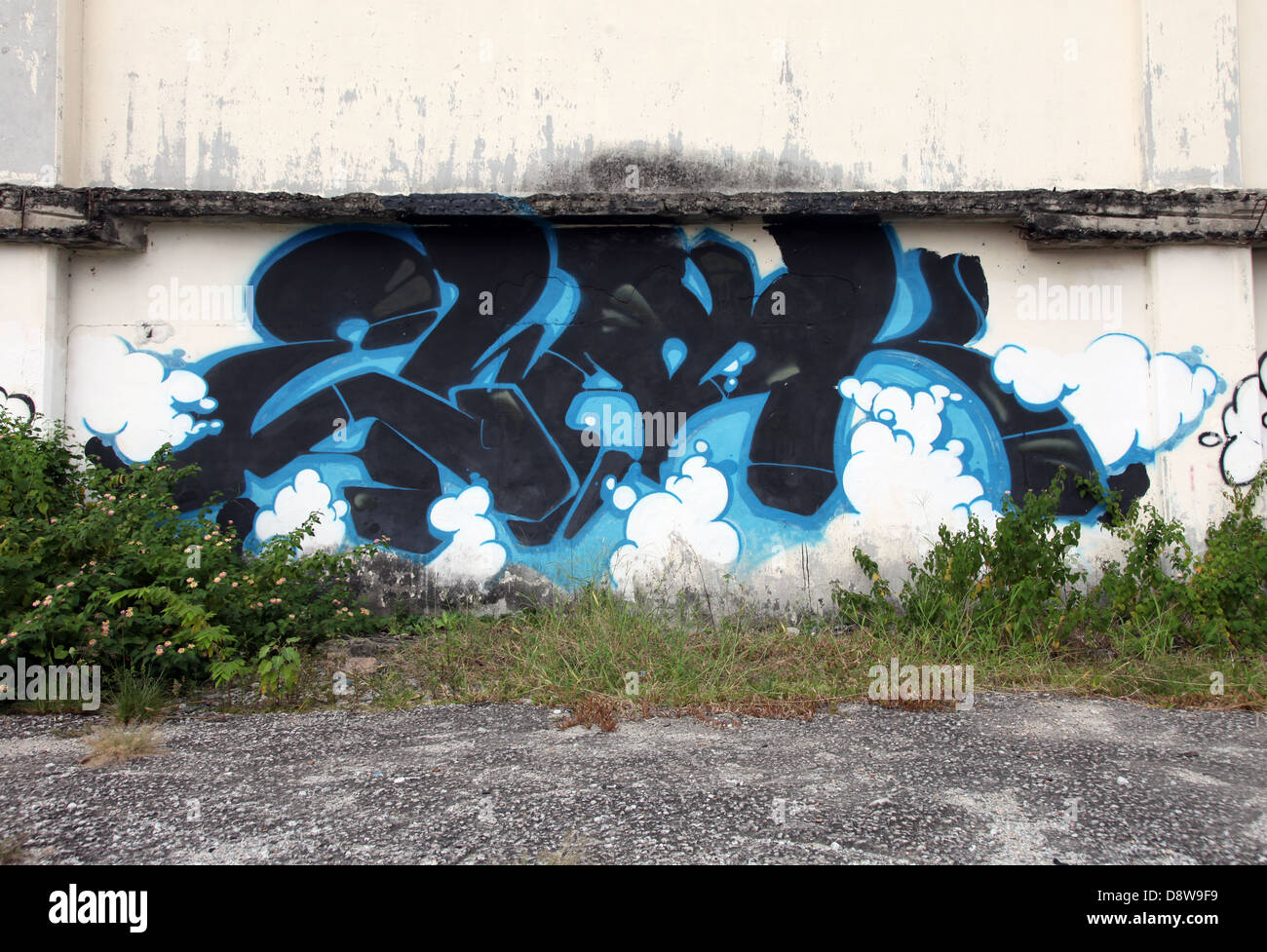 Es ist ein Foto von einer blauen Graffiti gegen eine zerstörte Wand in einer Einöde einer Stadt in Malaysia. Wir können sehen, dass es ein Industriegebiet ist Stockfoto