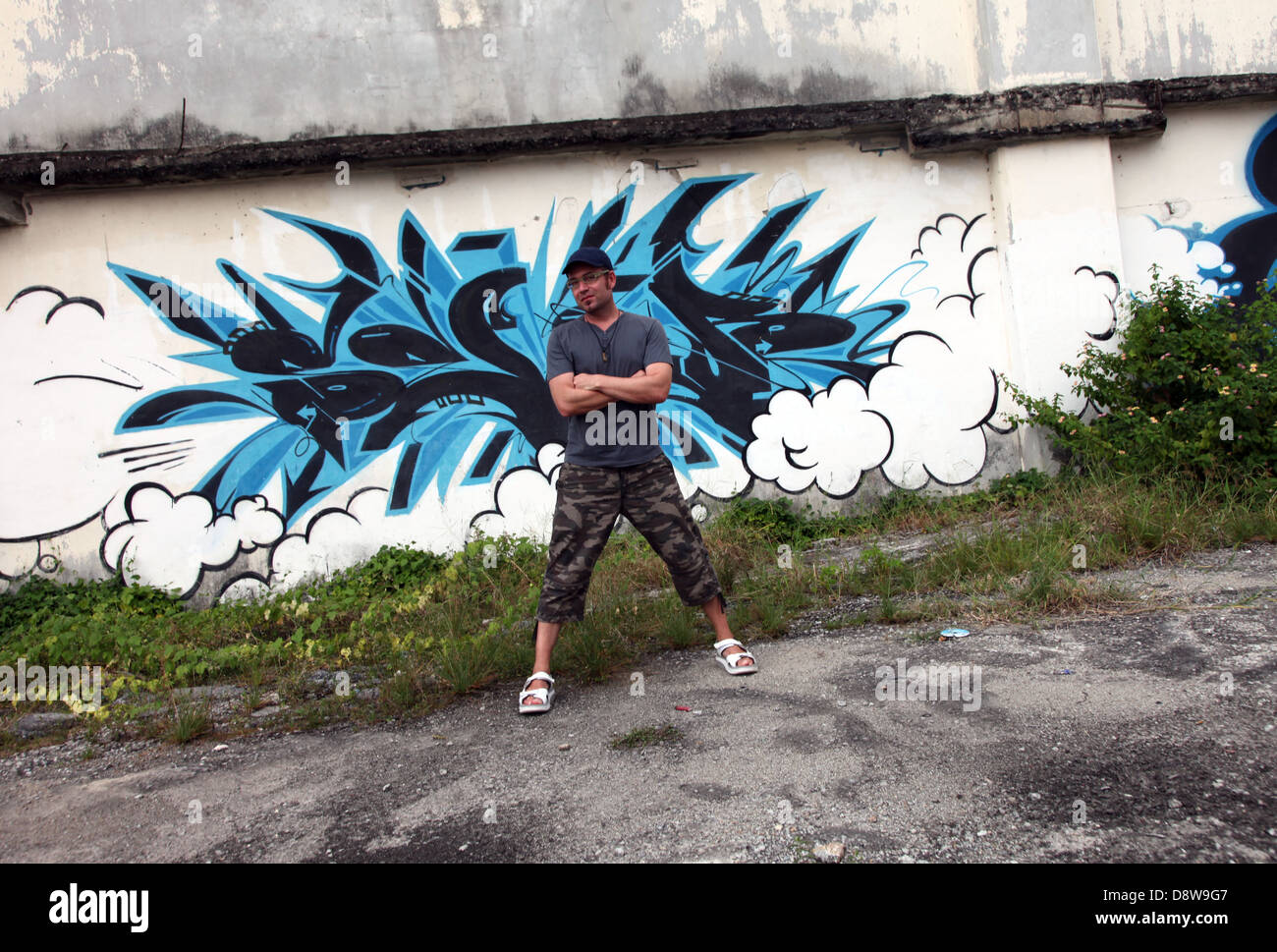 Es ist ein Foto von einer blauen Graffiti gegen eine zerstörte Wand in einer Einöde einer Stadt in Malaysia. Wir können sehen, dass es ein Industriegebiet ist Stockfoto