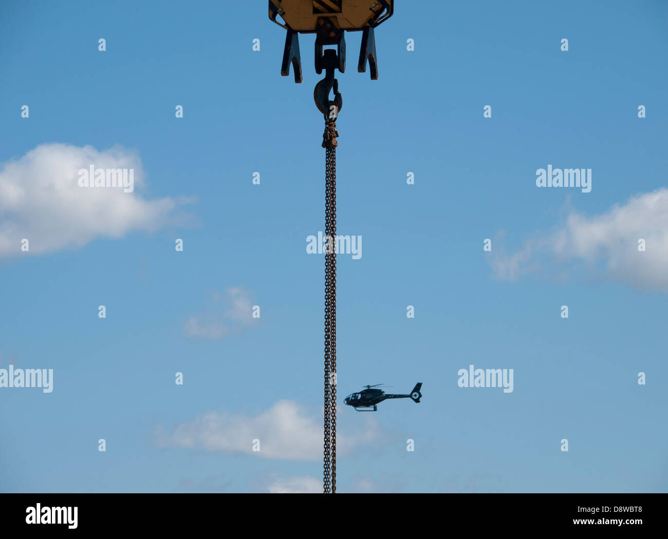 Baukran und ein Hubschrauber mit einem blauen Himmel Stockfoto