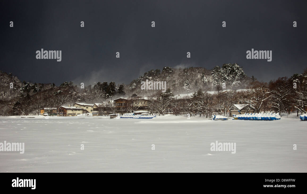 Dunkel bewölkter Himmel umhüllt einen gefrorenen See Towada - alle Bootfahren Aktivitäten kommen zum Stillstand im Winter Stockfoto