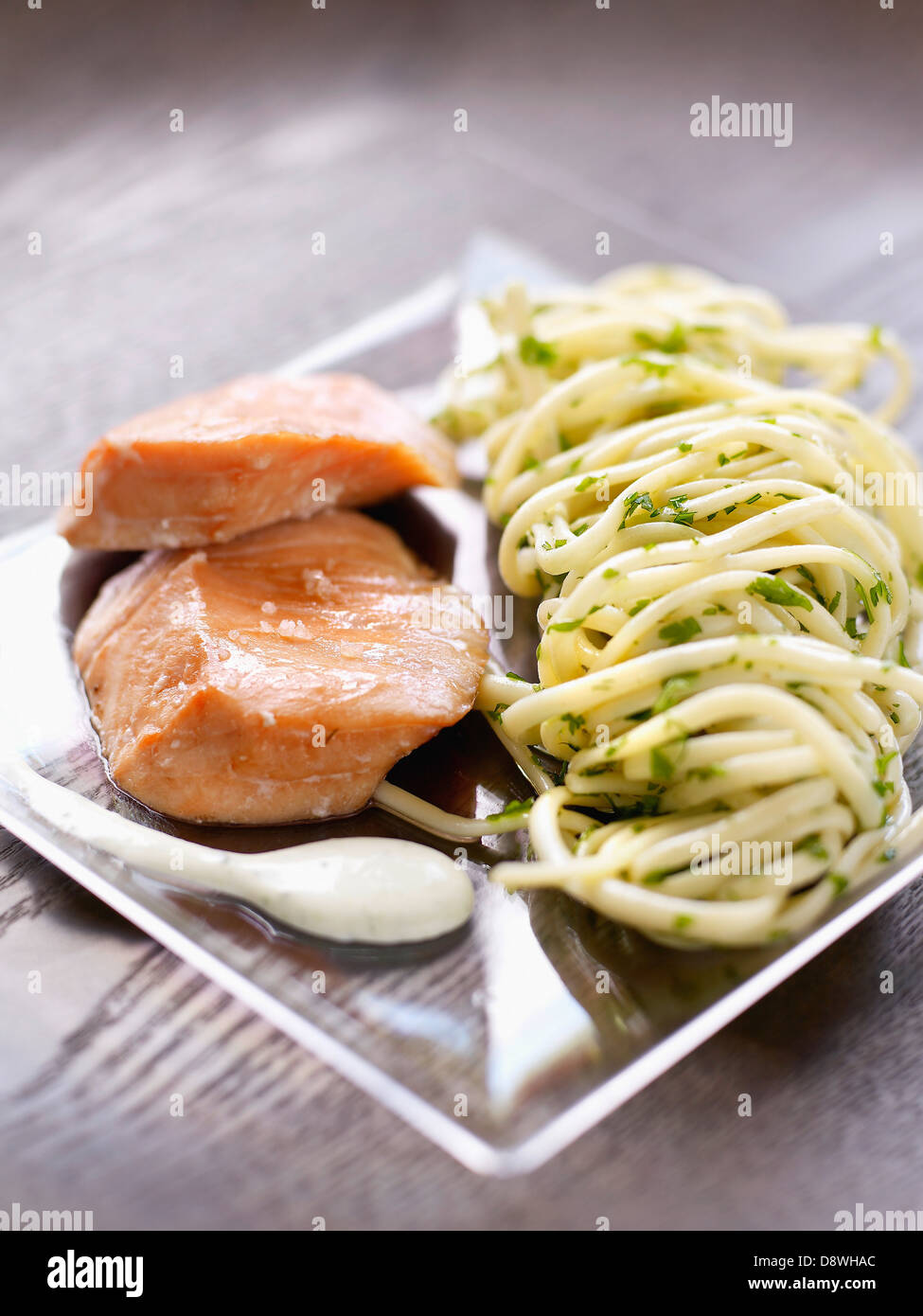 Lachs mit Fleur de Sel Salz, Meeresspaghetti mit Kräutern Stockfoto
