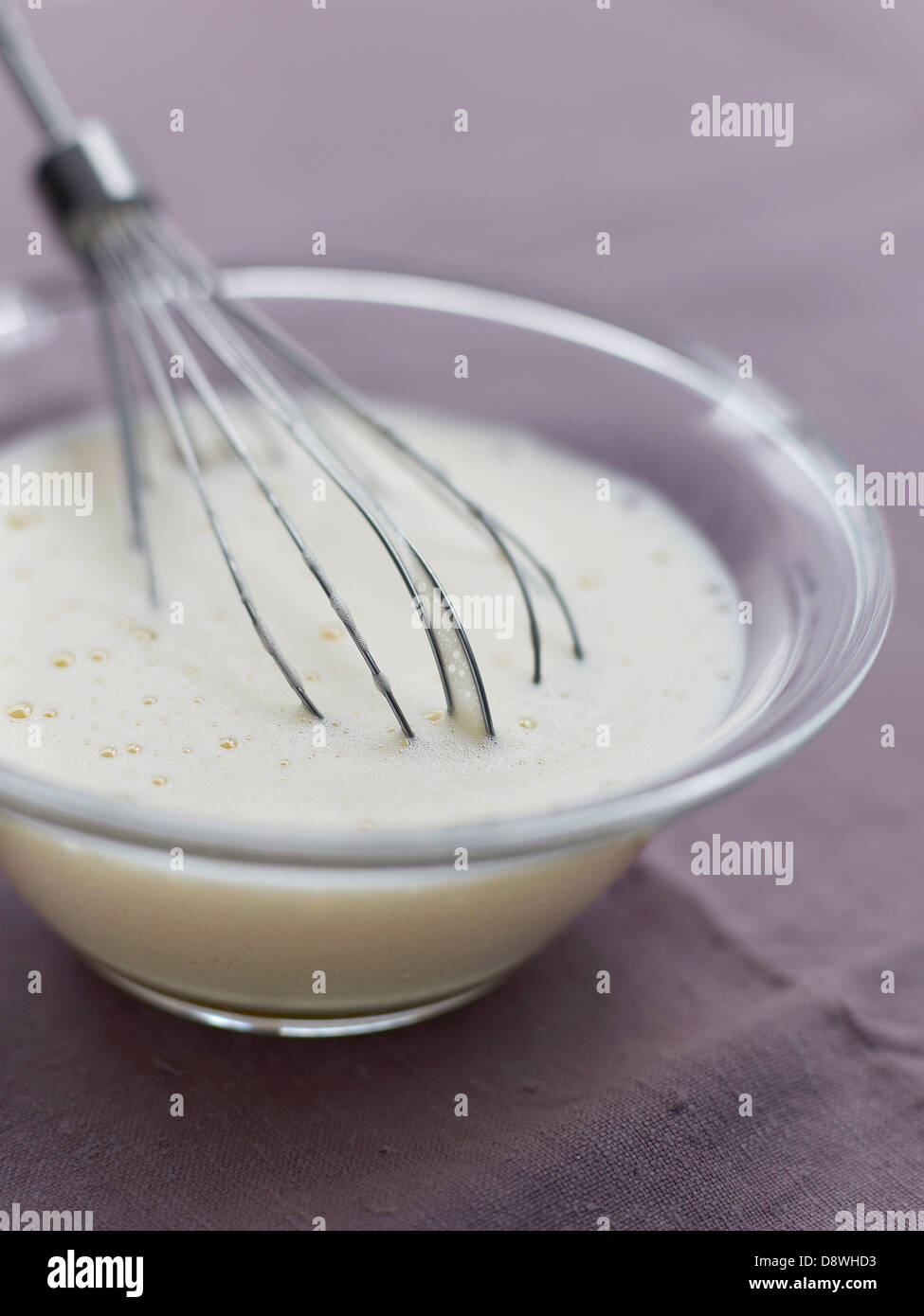 Zusammen zu schlagen, den Eiern und den Puderzucker mit einem Schneebesen Stockfoto