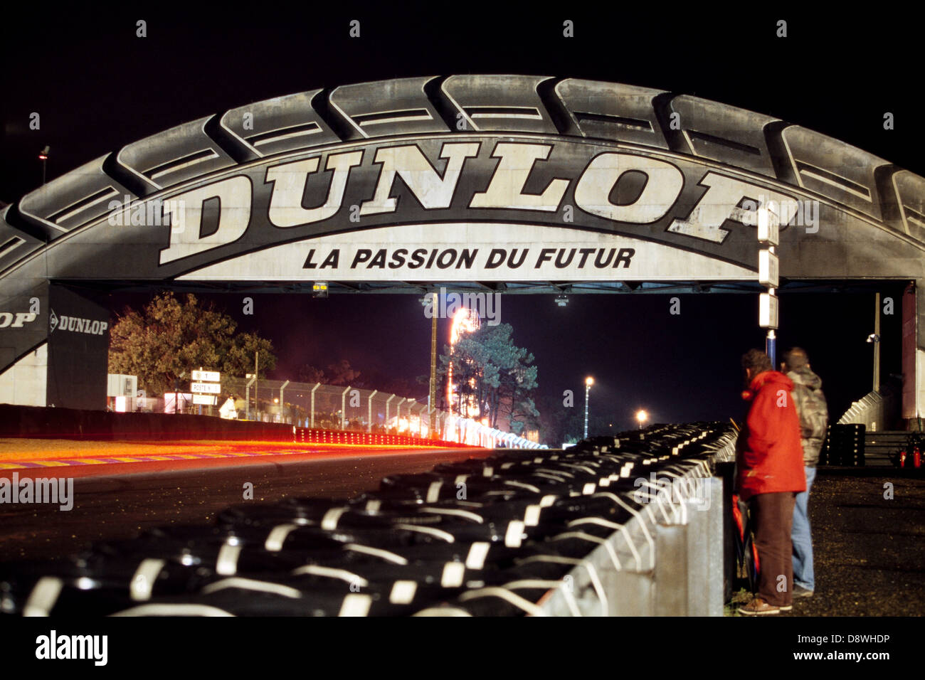 Autos schaffen helle Streifen, wie sie in der Nacht während der 24-Stunden-Langstreckenrennen in Le Mans im Jahr 2001 unter der Dunlop Brücke passieren Stockfoto