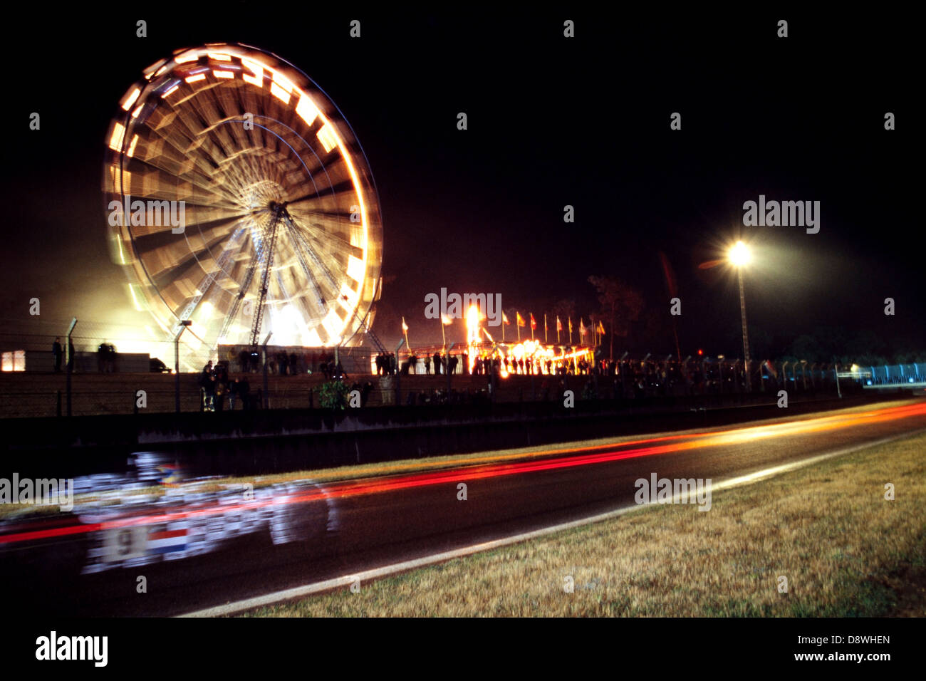 Ein Auto übergibt das Riesenrad in der Nacht während der 24-Stunden-Langstreckenrennen in Le Mans im Jahr 2001 Stockfoto