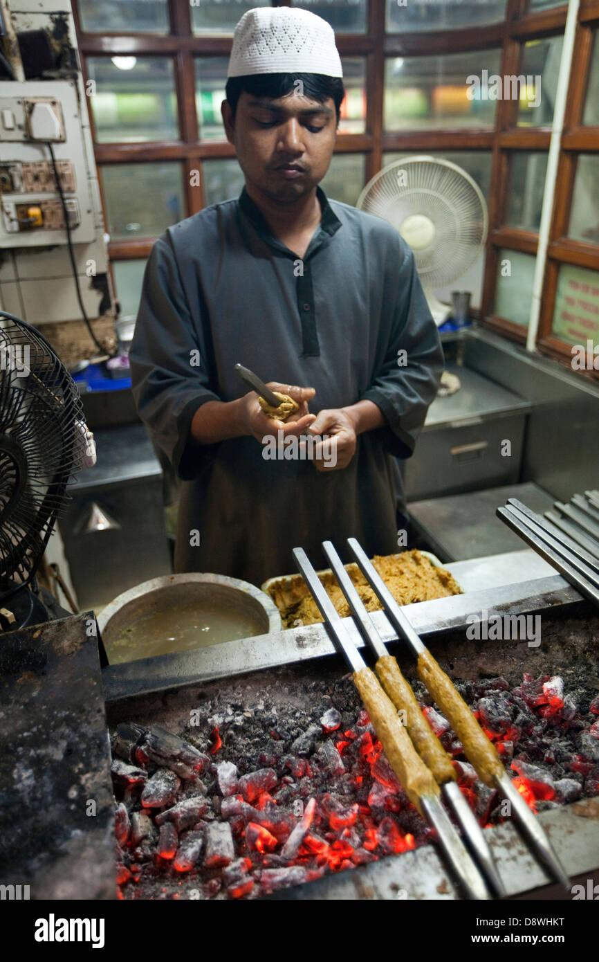Ein Mann macht und Grillplatten Kebab Karims Restaurant, Old Delhi Stockfoto