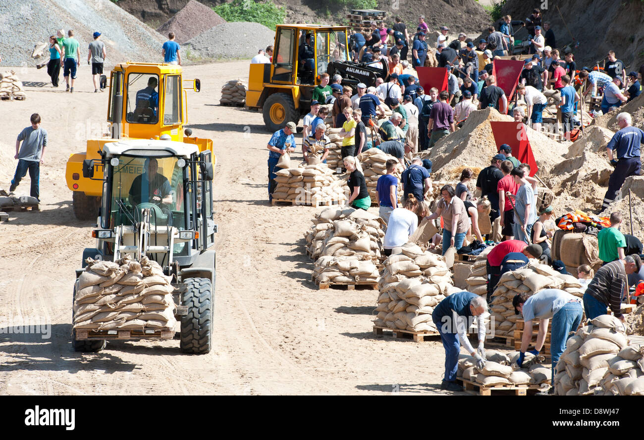 Freiwillige Helfer füllen Sandsäcke in einer Kiesgrube in der Nähe von Tramm, Deutschland, 5. Juni 2013. Die Elbe ist zu Rech Rekordwasserständen in Niedersachsen zum Wochenende hin zu befürchten. Foto: PHILIPP SCHULZE Stockfoto