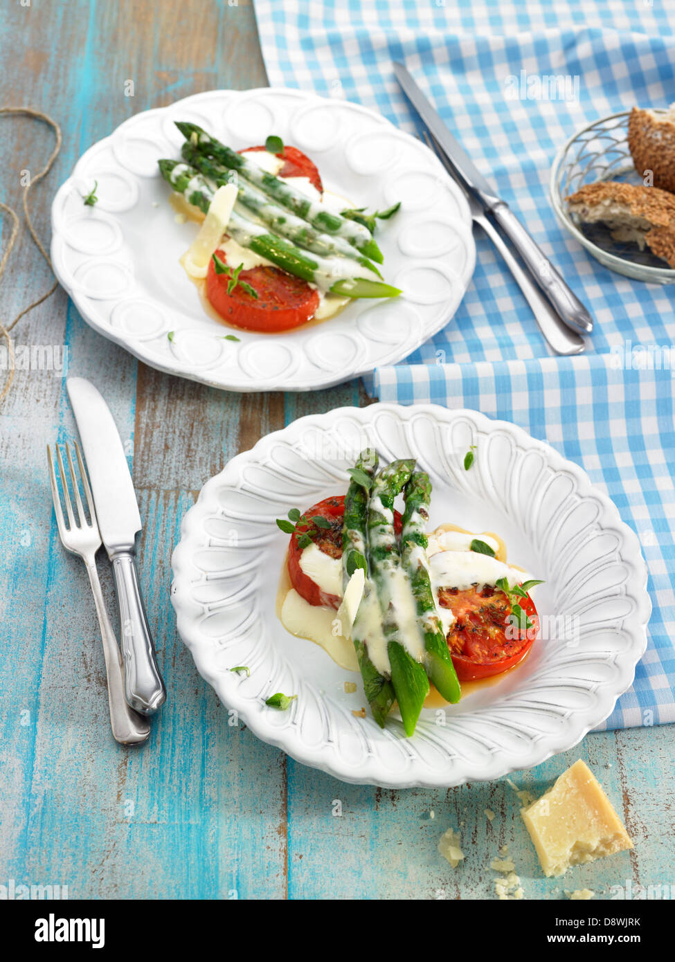 Grüner Spargel und Tomaten mit Parmesan-Sahne und oregano Stockfoto